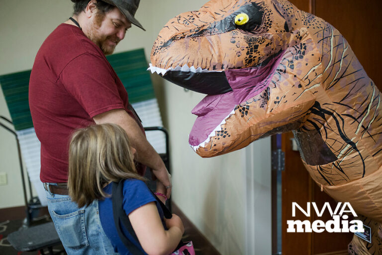 NWA Democrat-Gazette/CHARLIE KAIJO Joshua Debes of Ozark and Shaylea Debes, 6 of Springdale say hello to Nikolas Siler, 15 of Rogers dressed as a T-Rex on Sunday, November 12, 2017 at Four Points Sheraton Hotel in Bentonville. The Hotel hosted the Arkansas Anime Festival - Northwest Arkanas Edition 2017. Fans enjoyed product displays, gaming parties and artist Q&As